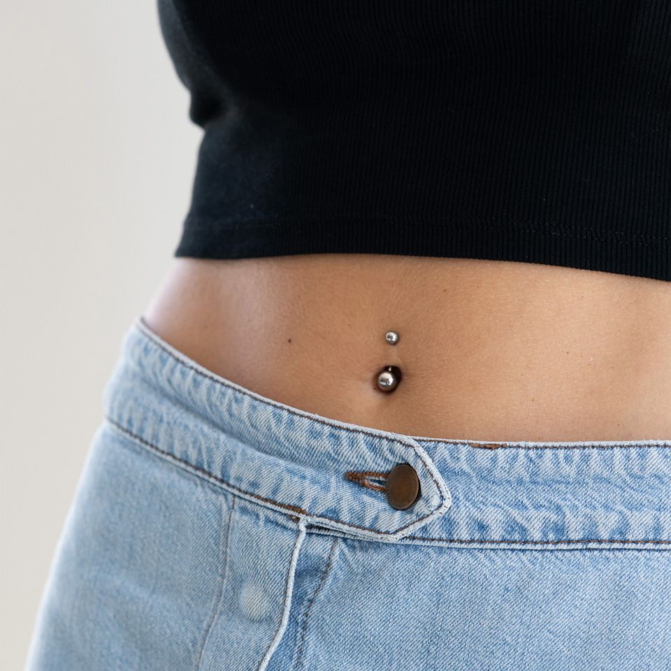 Navlepiercing af titanium i forskellige farver