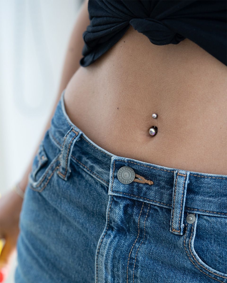 Navlepiercing af titanium med to sten