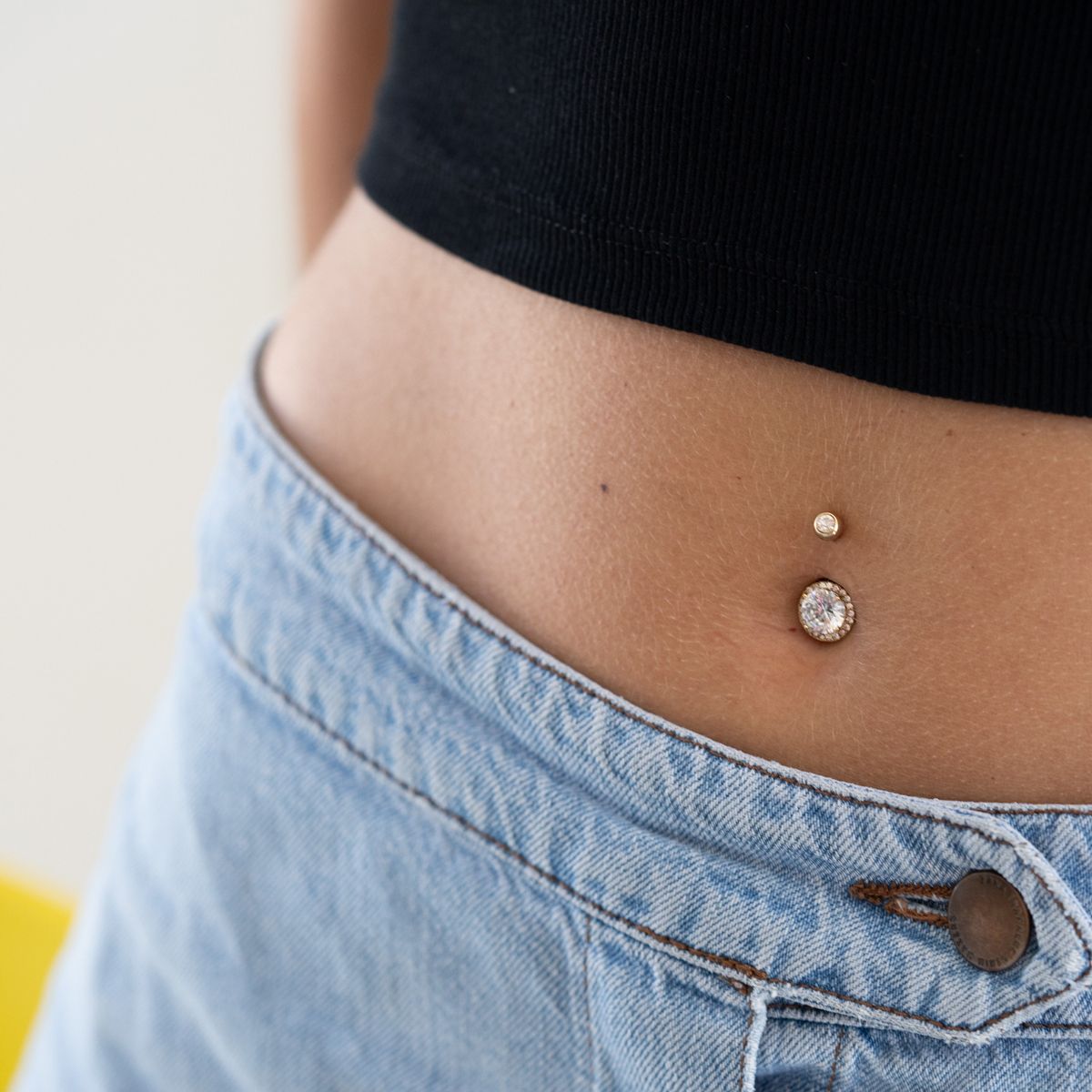 Navlepiercing med facetskåret centersten