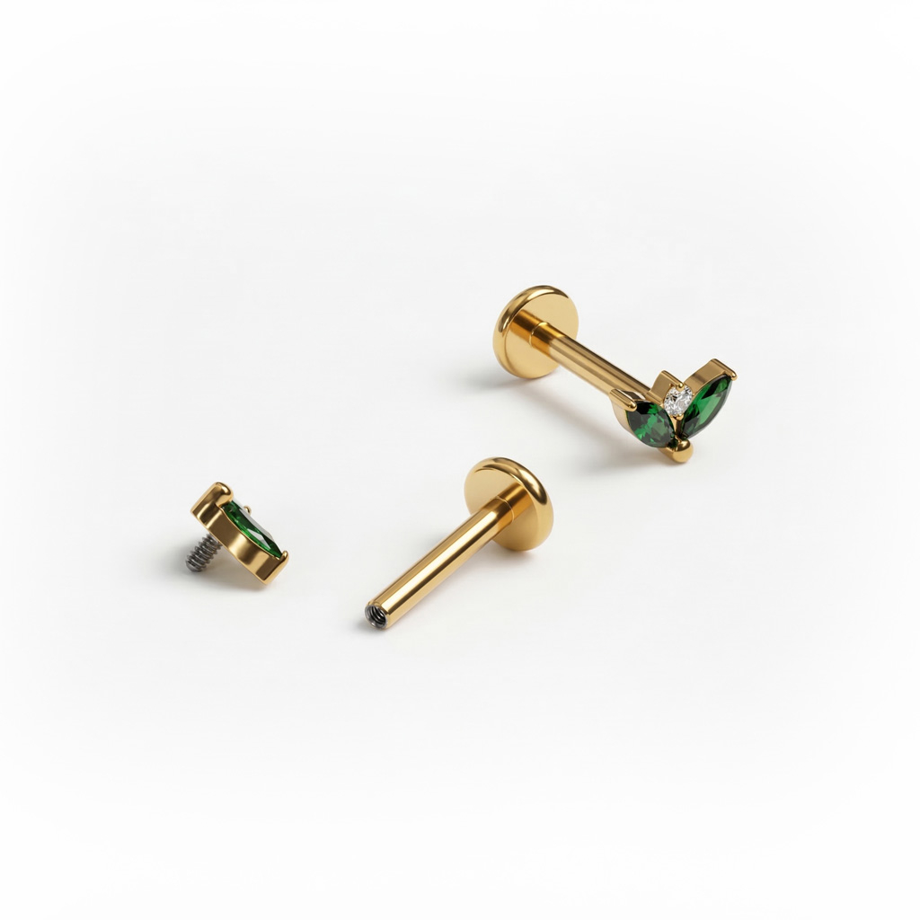 Titaniumlabret med to smaragdfarvede sten