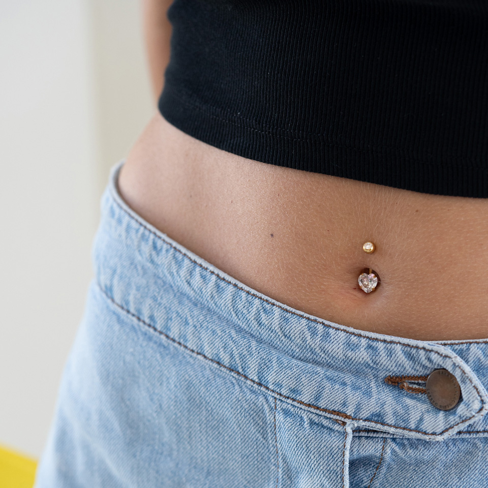 Navlepiercing i flere farver med hjertesten